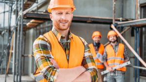 Bilde av 3 arbeidere i oransje vester med hjelm