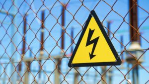 Et skilt som indikerer høy spenning på et gjerde som hindrer adtkomst til et høyspenningsanlegg